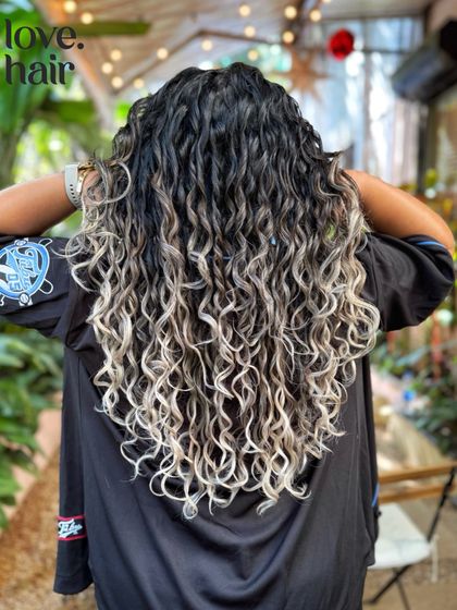 Another back view of the stunning silver-blonde curly balayage, showing off the incredible length and health of the curls even after bleaching.