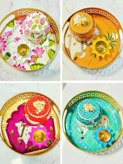 Our collection of Pichwai tray sets comes in various vibrant colors and designs. Each set includes a matching jar and a brass lotus diya, making it a complete and beautiful addition to your festive decor.