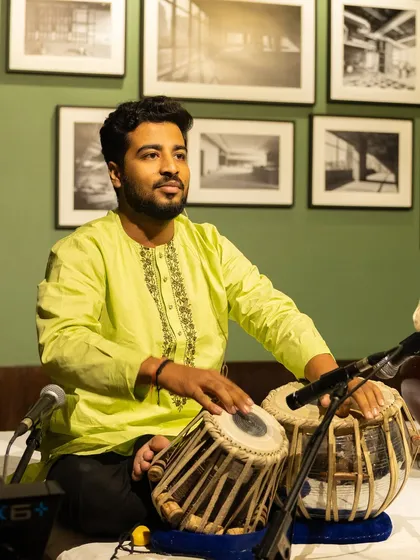 Performing at an intimate gathering, with a beautiful art-filled backdrop.