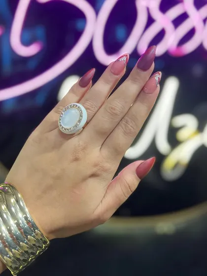 Make a statement with this custom stiletto nail set. The design combines a matte mocha base with a deep red, accented by a reverse French tip in sparkling silver glitter for a bold, high-fashion look.