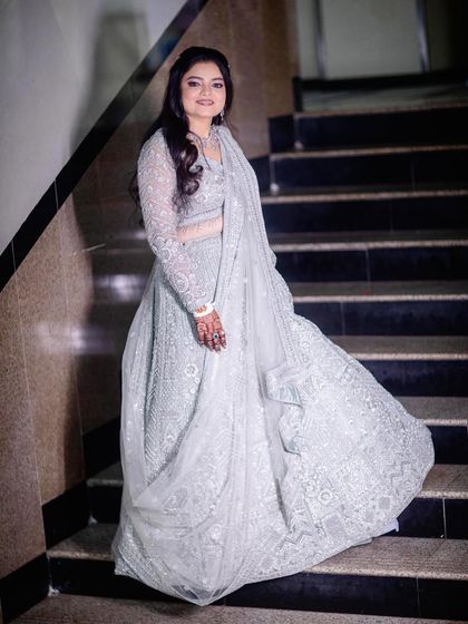 Another shot of the client on the stairs, showing the full flare and intricate work of the silver-grey outfit.