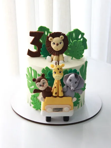 A sweet and simple jungle safari cake for a 3rd birthday. The fondant animals are all packed into a jeep, ready for an adventure.