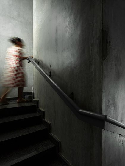 The concrete staircase in our studio is minimally detailed to emphasize the raw texture of the material. The lighting is designed to graze the wall, highlighting its imperfections and creating a moody, atmospheric path between floors.