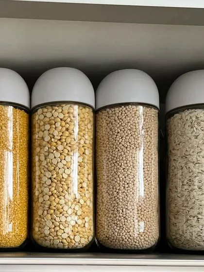 An organized kitchen can also be beautiful. We use simple techniques like grouping items by color and using uniform containers to create a visually pleasing aesthetic. This shelf of organized pulses in clear jars adds a touch of calm and order to the kitchen.