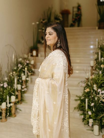 A profile shot capturing the joy of the celebration. The backdrop of cascading flowers and soft candlelight on the stairs highlights the warm and luxurious atmosphere we created for this milestone birthday event.