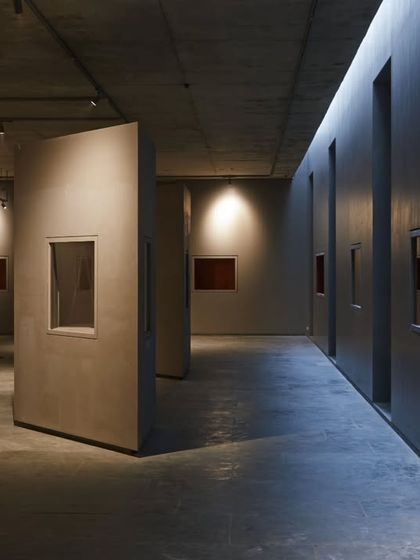 The interior of the Vismaya museum is a carefully composed sequence of spaces. Here, freestanding partitions and controlled lighting create a dramatic, moody atmosphere, focusing the visitor's attention on the illuminated artworks.