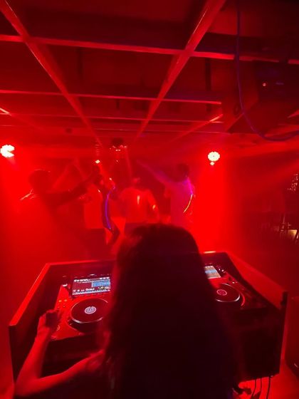 A classic over-the-shoulder shot from the DJ booth, showing my view of the dance floor under the red lights.