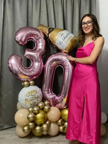 Celebrate a milestone with a custom balloon bouquet. This arrangement for a 30th birthday features large foil numbers, a champagne bottle balloon, and a personalized tag.
