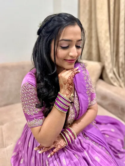 A quiet, beautiful moment. The soft lilac tones of her outfit are complemented by the gentle, glowing makeup.