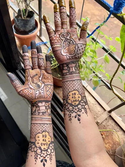 Another angle of the whimsical mouse-themed baby shower mehendi, showing the design against a natural green background.