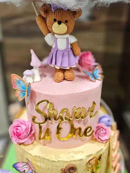 A close-up of the cute teddy bear figurine on the fairy cake.
