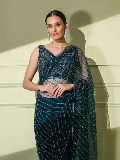 A closer shot of the teal geometric saree, focusing on the detailed blouse and the sheer, elegant organza fabric.