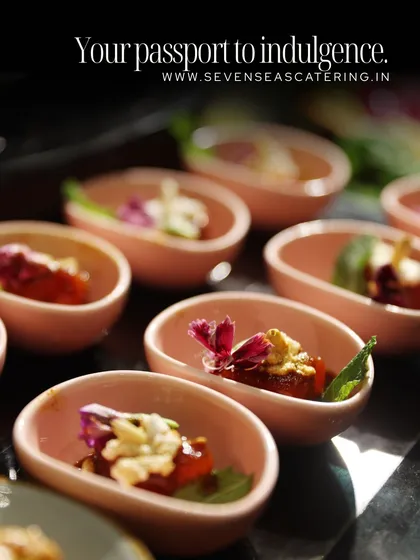 Your passport to indulgence. These single-bite appetizers in delicate pink bowls are garnished with edible flowers, promising a journey of flavour.