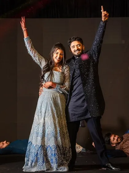 The finale pose of an energetic friends' performance, with the couple taking center stage.