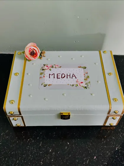 A personalized keepsake trunk for a bridesmaid named Medha. The pastel green and gold details, along with the custom name tag, make this a truly special proposal gift.