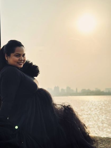 This black tiered gown combines comfort and style with its full-sleeved top and voluminous net skirt. It's a versatile piece that works for both studio and outdoor shoots.