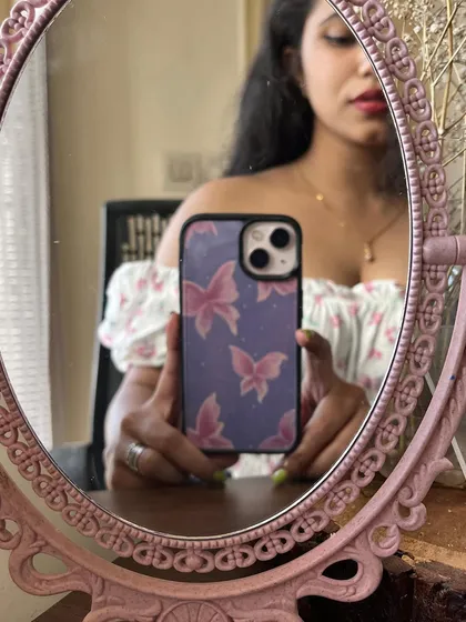 A mirror selfie showing off my hand-painted butterfly phone case. It's a simple way to customize your look and carry a piece of my art with you.