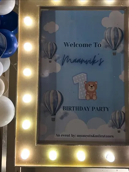 The lit-up welcome sign for Maanvik's celebration, featuring a cute teddy bear in a hot air balloon.