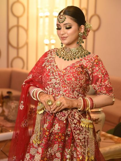 A moment of bridal grace. The heavy jewellery, including the kaleeras and rings, completes this bride's traditional yet glamorous look.