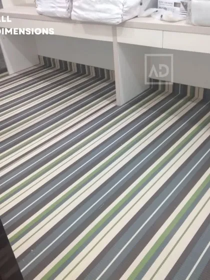 Striped carpet tiles installed in an office space, fitting neatly under the desks. This design is modern and helps to visually elongate the room.
