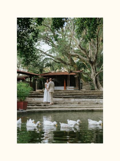 A couple stands by the pond, with our resident ducks adding a touch of unexpected charm to this serene, wide-angle shot.