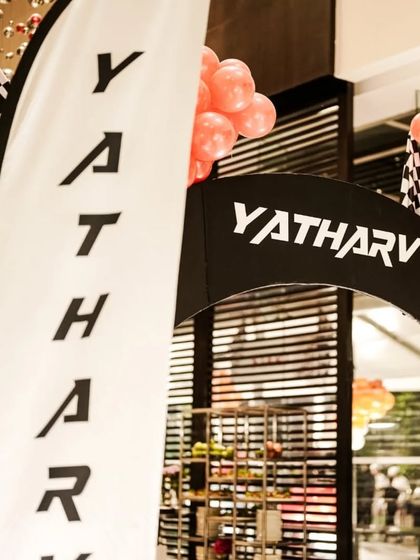 A personalized race-themed entrance arch welcomes guests to the party. The custom branding and checkered flag details create an immersive experience from the moment guests arrive.