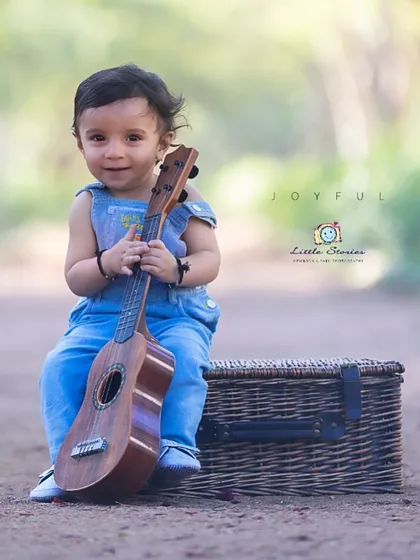 A little musician in the making. This portrait captures a sweet, quiet moment of discovery as he examines the instrument.
