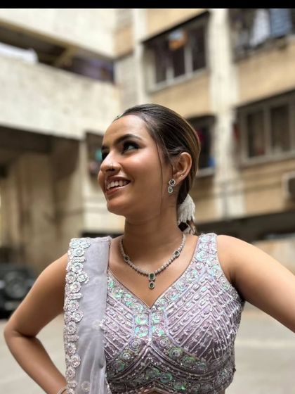 A happy, natural shot of the client outdoors in the lavender lehenga.