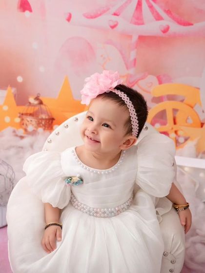 A close-up of the birthday girl, her happy smile lighting up the entire whimsical, star-filled studio setup.