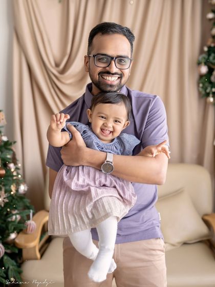 A father and daughter sharing a happy moment, with a Christmas tree in the background.