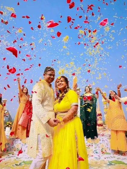 A wide-angle shot of the flower shower, capturing the blue sky and the explosion of colorful petals. It's a moment of pure celebration.