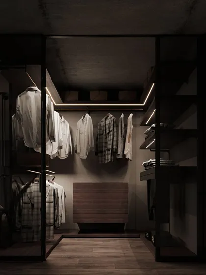 A walk-in closet designed with a moody, sophisticated palette. We used smoked glass doors, dark wood, and integrated LED strip lighting to create a space that feels like a personal boutique, where every item is beautifully displayed.