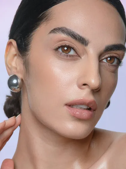 A simple, elegant portrait. The clean, glowing skin and neatly styled hair create a timeless look that is highly sought after in commercial and beauty advertising.