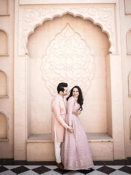 A full-length portrait of the couple in a beautiful architectural setting. The symmetry of the location and the couple's pose create a visually pleasing and elegant image.