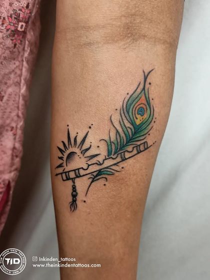 This colorful design combines Lord Krishna's flute and a peacock feather with the radiant sun. The vibrant greens and blues of the feather bring the piece to life, symbolizing divine music, beauty, and enlightenment.