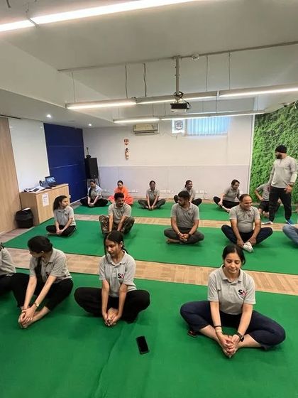A seated forward bend practice during the corporate session to help release tension in the lower back and hamstrings.