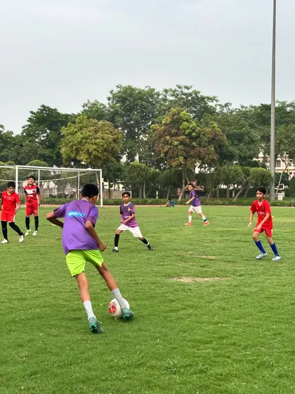 A player in our purple kit looks for a pass during a competitive game. Vision and decision making are key skills we develop.