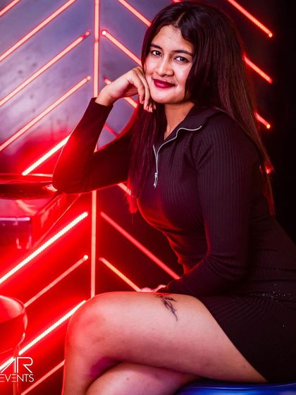 A guest posing against the red neon lights.