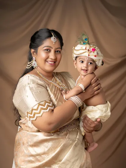 A mother and her little Krishna, dressed in beautiful traditional clothing.