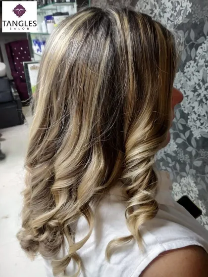 This side profile shot captures the beautiful way these golden highlights frame the face. The soft curls at the end help to showcase the different tones and the overall healthy shine of the hair after the service.