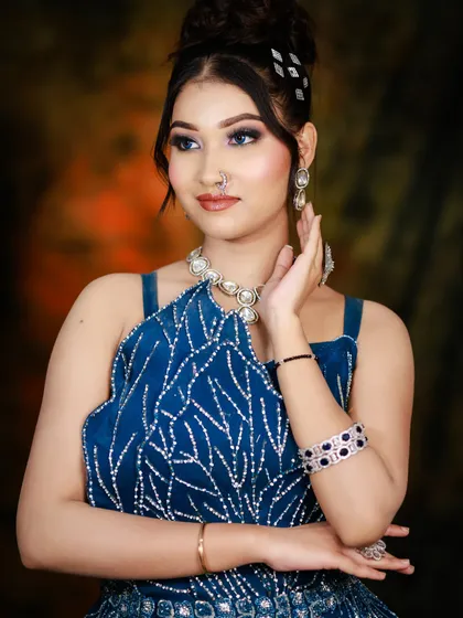 A full-length pose showcasing the elegant blue gown and the sophisticated updo. This is a perfect example of a modern reception or cocktail party look.