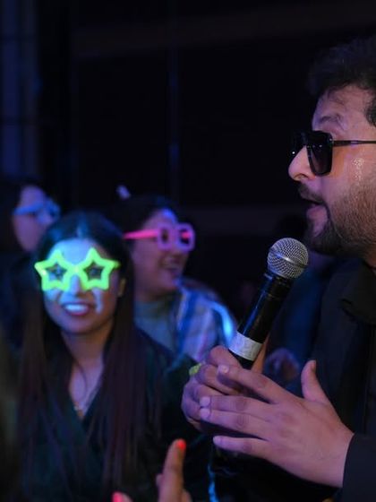 A singer interacting with the audience during a live show. These candid moments of connection between the performer and the crowd are essential to telling the event's story.