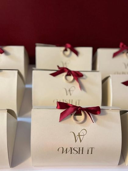 A closer view of the "Wishlet Kits" with their rich maroon ribbons. The simple, clean design makes them a versatile choice for any gifting need.