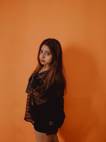 A confident and direct portrait that uses a simple, colorful background to make the subject stand out.