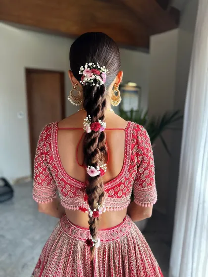 Fresh flowers in a bridal hairstyle add such a soft, romantic touch. For Neha's big day, we wove delicate florals into her thick, beautiful braid. This style is not only stunning but also light and comfortable for long wedding rituals.