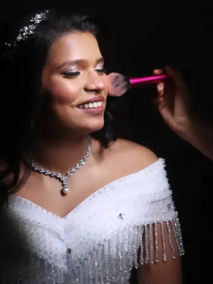 A dramatic, low-light shot of me applying blush. This photo emphasizes the contouring and highlighting techniques I use to sculpt and define the bride's features.