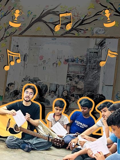 An instructor sits with a group of boys, teaching them a song with his guitar. The informal, circular seating arrangement encourages collaboration and peer-to-peer learning.