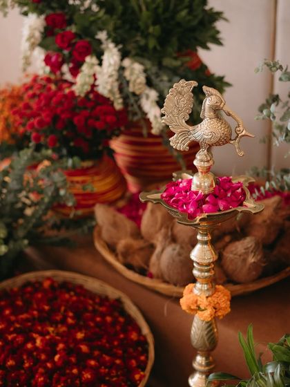 Every great celebration begins with intention. This Ganesh Pooja setup features traditional elements like a brass peacock diya and fresh flowers, creating a serene and blessed start to the wedding festivities.