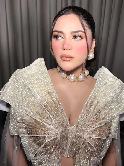 The side profile shows off the large pearl earrings that complete this avant-garde look.