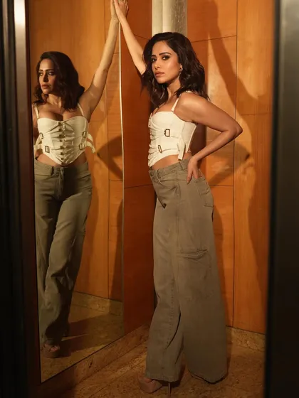 This standing pose uses the reflection to create a dynamic composition, highlighting the subject's profile and full figure simultaneously.